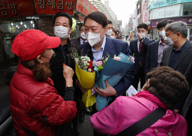 윤석열 국민의힘 대선 경선 후보가 4일 경기도 의정부 제일시장을 방문해 지지자에게 꽃다발을 받고 있다./국회사진기자단 2021.11.04