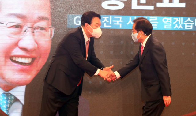 윤석열(왼쪽) 국민의힘 대선 후보가 5일 서울 용산구 백범김구기념관에서 열린 국민의힘 제2차 전당대회에서 악수하고 있다./연합뉴스