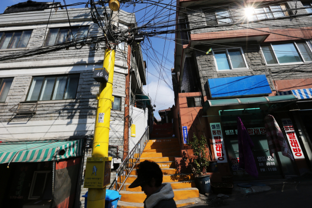 한 시민이 지난 2013년 범죄예방디자인(CPTED) 기법이 적용된 서울 마포구 염리동 골목길을 지나고 있다. CPTED가 적용된 이후 이 지역 주민이 자신과 가족에 대해 느끼는 범죄 두려움이 각각 9.1%와 13.6% 감소한 것으로 나타났다./연합뉴스