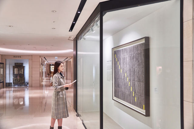 고객이 서울 신라호텔 지하 1층 아케이드에 전시된 '폴 인 아트'’ 패키지의 작품을 살펴보고 있다./사진 제공=호텔신라