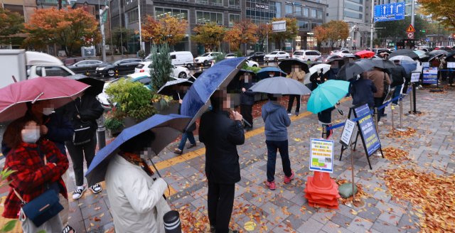 8일 오전 서울 송파구 보건소 코로나19 선별검사소에서 시민들이 검사를 받기 위해 우산을 쓴 채 차례를 기다리고 있다./연합뉴스