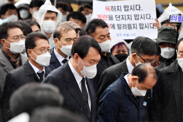 윤석열(왼쪽) 국민의힘 대선 후보가 10일 국립5·18민주묘지를 참배하고 있다. 윤 후보는 5·18민주묘지 추모탑에 헌화·분향하려 했으나 반대하는 시민들에 가로막혀 추모탑 입구에서 묵념으로 참배를 대신했다. /광주=사진공동취재단