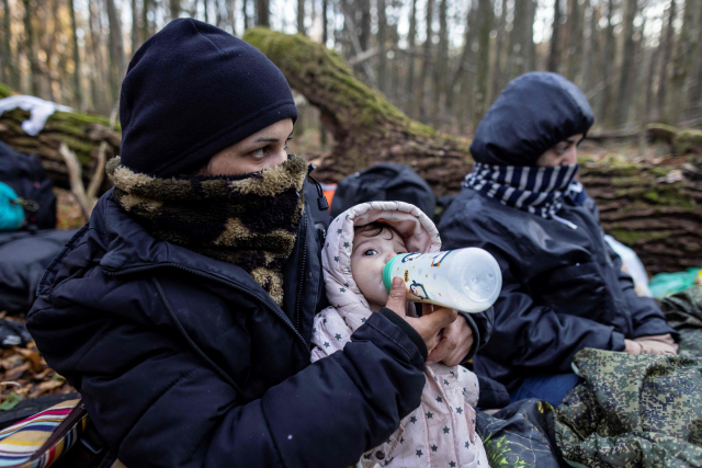 폴란드-벨라루스 국경서 노숙하며 젖먹이는 중동 이주민 여성. 벨라루스와 국경을 접한 폴란드 나레프카 인근 숲속에서 9일(현지시간) 이라크 쿠르드족 여성이 어린아이에게 젖병을 물리고 있다. 5개월 된 영아를 포함해 미성년자 7명 등 3대에 걸친 이들 쿠르드 가족 16명은 유럽행을 바라며 이곳에서 20일째 노숙 중이다. 난민을 포함한 이들 이주민의 대다수는 전쟁과 빈곤을 피해 중동에서 동유럽 국가 벨라루스로 건너왔으며 새 삶을 찾아 폴란드를 통해 유럽연합(EU) 회원국으로 가길 원하고 있다./AFP연합뉴스