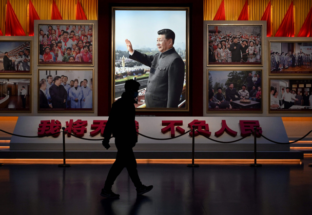 11일 중국 수도 베이징에 있는 중국공산당역사박물관에 전시된 시진핑 국가 주석의 사진 옆을 한 시민이 지나가고 있다. 최근 중국은 시진핑 주석에 대한 우상화를 강화하고 있다. /AFP연합뉴스
