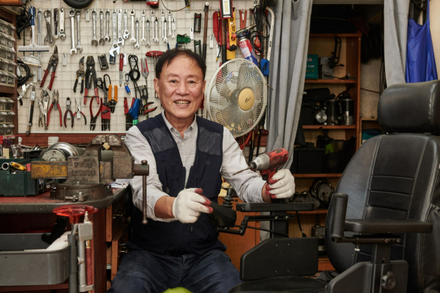 제21회 우정선행상 대상 수상자인 신동욱 씨가 휠체어 수리 작업을 하고 있다. /사진 제공=코오롱