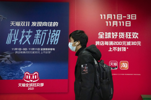 11일 중국 베이징의 한 지하철에서 한 남성이 알리바바 광군제 홍보판 앞을 지나가고 있다. /AP연합뉴스