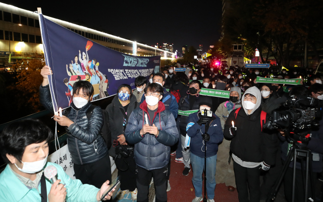 '비정규직 이제그만 1100만 비정규직 공동투쟁' 관계자들이 12일 오후 서울 종로구 청계천 전태일 동상 앞에서 '전태일 배신정권, 일하다 죽지않게 차별받지 않게' 촛불집회를 하고 있다./연합뉴스