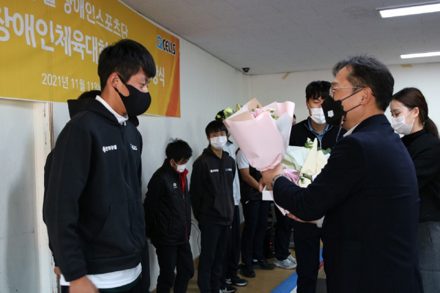 임원배(오른쪽) 한화큐셀 전무가 제41회 전국장애인체육대회에서 지적장애인 축구 종목 금메달을 획득한 박재원 선수에게 꽃다발을 건네고 있다. /사진제공=한화큐셀