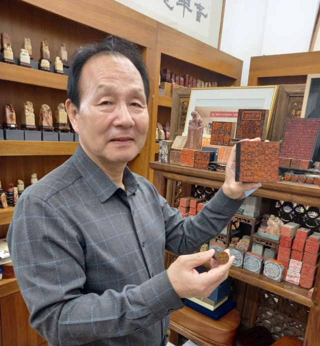 황보근 명장이 서울 인사동 인예랑 사무실에서 자신이 만든 인감도장과 전각 작품에 관해 설명하고 있다.