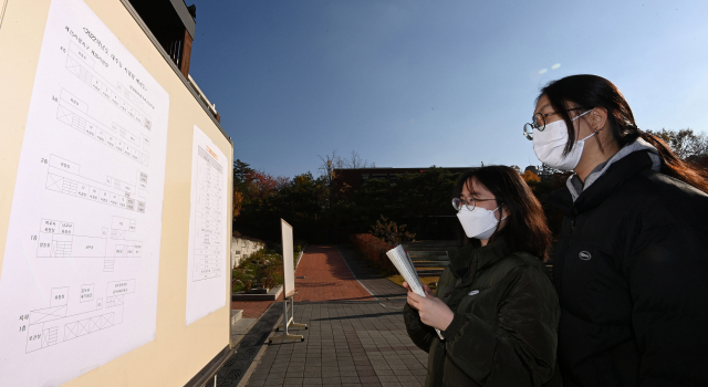 2022학년도 대학수학능력시험을 하루 앞둔 17일 서울 중구 이화여자외국어고등학교에서 예비 소집에 참여한 수험생들이 시험장 배치도를 확인하고 있다. /사진공동취재단