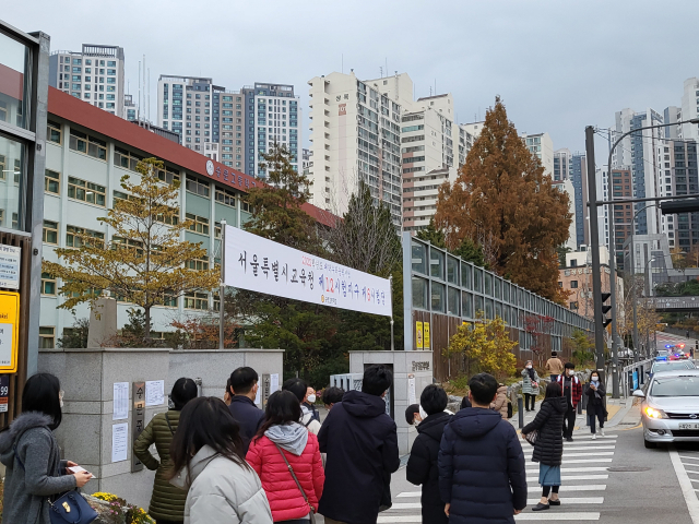 18일 오전 대학수학능력시험(수능)이 치러지는 서울 마포구 숭문고등학교 앞에서 학부모들이 자녀들을 시험장에 들여보내고 있다./심기문기자