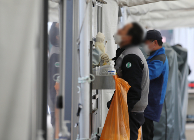 코로나19 임시 선별검사소에서 시민들이 진단검사를 받고 있다./연합뉴스