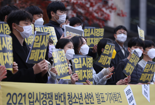 입시경쟁에 반대하는 단체 회원들이 2022학년 대학수학능력시험 날인 18일 오전 서울 중구 파이낸스센터 앞에서 입시경쟁 반대 선언 기자회견을 열고 손팻말을 들고 있다./연합뉴스