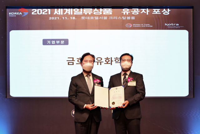 18일 서울 소공동 롯데호텔에서 열린 ‘2021 세계일류상품 유공자 포상식’에서 고석범(오른쪽) 금호석유화학 기술·에너지 사업 임원이 박진규 산업통상자원부 차관과 기념 촬영을 하고 있다./사진제공=금호석유화학