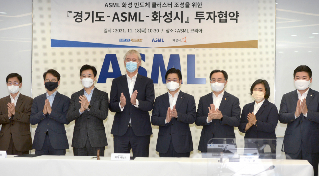 문승욱(왼쪽 여섯번째) 산업통상자원부 장관이 18일 경기도 화성에서 열린 ‘ASML 화성 반도체 클러스터 조성을 위한 업무 협약식’에서 피터 베닝크(// 네번째) ASML 최고경영자(CEO)를 포함한 관계자들과 기념 촬영을 하고 있다. ASML은 지난 5월 산업부와 투자협약을 체결하고 2025년까지 2,400억원을 투자해 경기도 화성에 EUV 및 DUV 노광장비 엔지니어를 위한 트레이닝센터와 재제조센터 등이 있는 첨단 클러스터를 조성하기로 했다./사진제공=산업통상자원부