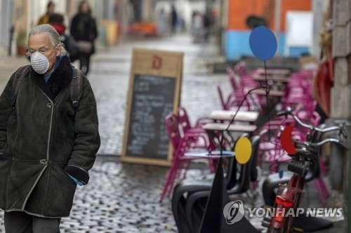 (17일(현지시간) 벨기에 브뤼셀에서 한 남성이 마스크를 쓴채 걸어가고 있다./AP연합뉴스