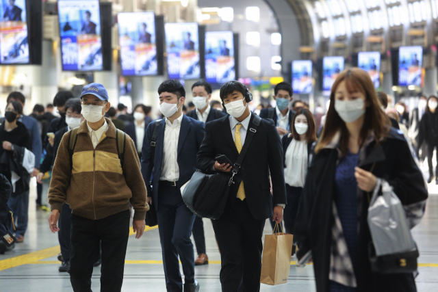 지난 16일 일본 도쿄에서 코로나19 확산을 막기 위해 마스크를 착용한 사람들이 건물 내부를 걷고 있다./AP연합뉴스