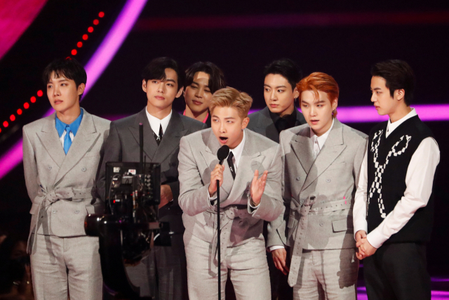 그룹 방탄소년단(BTS)의 리더 RM(가운데)이 21일(현지시간) 미국 로스앤젤레스에서 열린 아메리칸 뮤직 어워드 시상식에서 ‘올해의 아티스트’를 수상한 후 소감을 말하고 있다. /LA=로이터연합뉴스