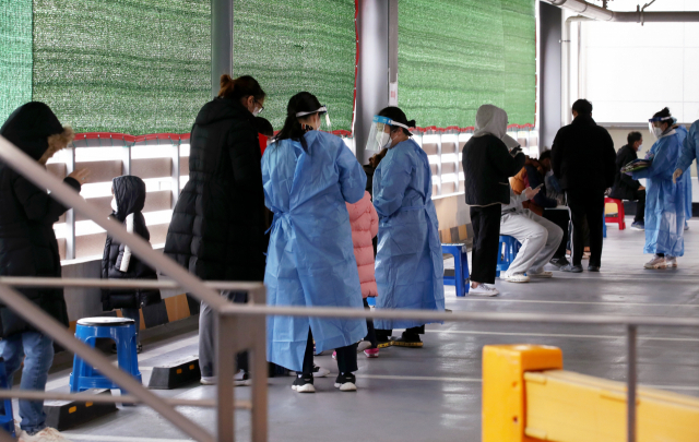 22일 광주 북구보건소 선별진료소에서 의료진들이 신종 코로나바이러스 감염증(코로나19) 검사를 받으려는 시민들의 문진표 작성을 돕고 있다./연합뉴스
