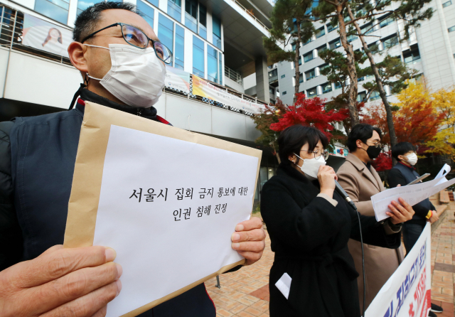 22일 오후 서울 중구 국가인권위원회 앞에서 열린 민주노총 기자회견에서 윤택근 민주노총 위원장 직무대행이 진정서를 들고 있다. / 연합뉴스