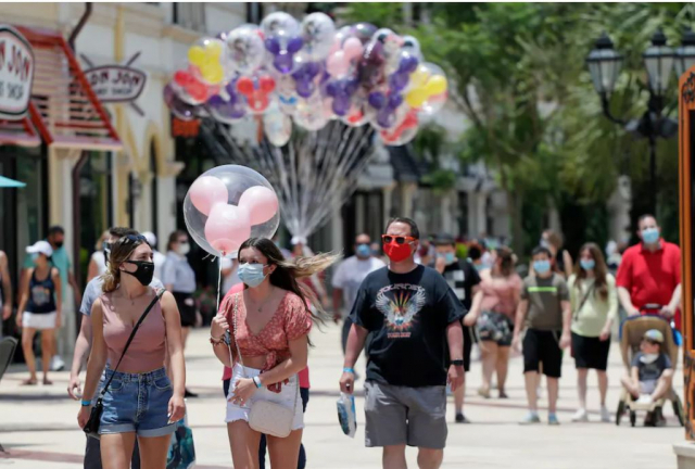 지난해 6월 코로나19 유행으로 인해 사람들이 마스크를 착용한 채 디즈니 스프링스 오락시설 근처를 거닐고 있다./워싱턴포스트 캡쳐