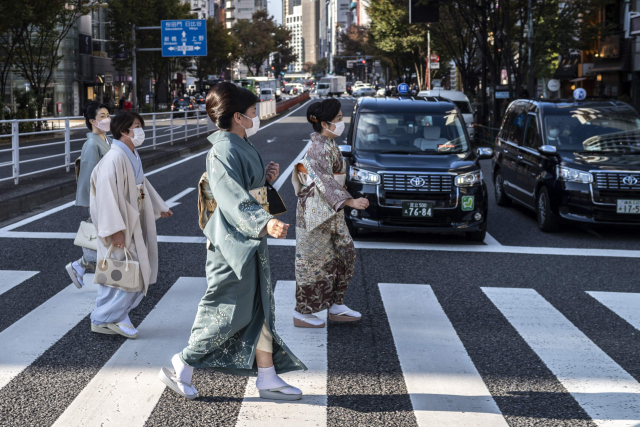 일본 전통의상인 기모노를 입은 여성들이 마스크를 쓴 채 도쿄 긴자 거리를 걷고 있다. /AFP연합뉴스