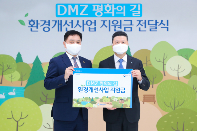 지난 25일 서울 중구 우리은행 본점에서 DMZ 평화의 길 환경개선사업지원금 전달식을 진행한 뒤 권광석 우리은행장(오른쪽)과 최영준 통일부 차관이 기념촬영을 하고 있다. 사진 제공=우리은행