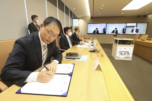 구현모 KT 대표가 지난 25일 화상으로 진행된 제11차 SCFA 총회에서 중국 차이나모바일, 일본 NTT 도코모와 전략적 제휴를 5년 연장하는 협약서에 서명하고 있다. /사진제공=KT