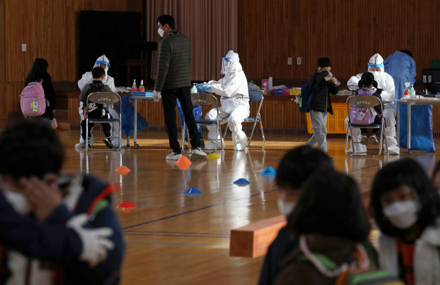 지난 22일 오후 광주 북구 한 초등학교에서 북구보건소 의료진들이 학생들의 신종 코로나바이러스 감염증(코로나19) 검체를 채취 하고 있다./연합뉴스
