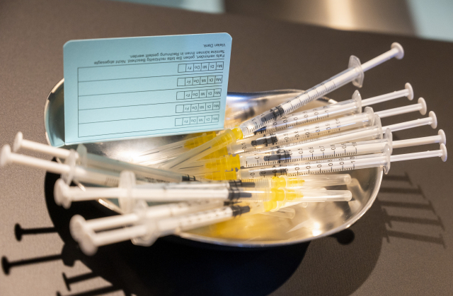 27일 독일 포츠담에서 열린 예방접종 캠페인 행사 중 화이자의 코로나19 백신 접종 주사기가 테이블에 놓여 있다./AP연합뉴스