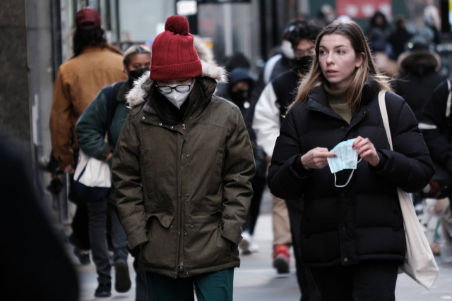 29일(현지시간) 미국 뉴욕시 맨하탄에서 사람들이 마스크를 쓴 채 걷고 있다. 새롭게 발견된 오미크론 변종이 전 세계 국가들에서 나타나면서 백신접종이 장려되고 있다./AFP연합뉴스