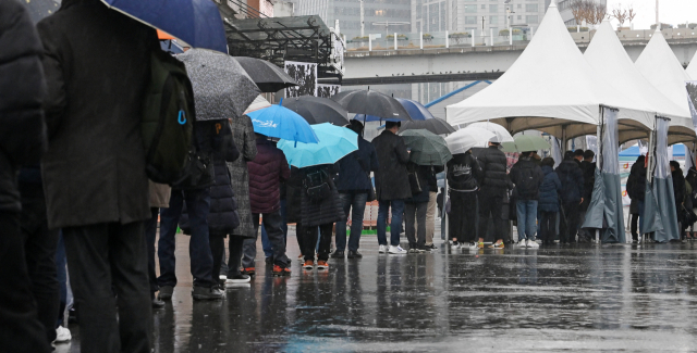 30일 서울역 광장 임시 선별 검사소를 찾은 시민들이 우산을 쓰고 검사를 기다리고 있다. /성형주 기자