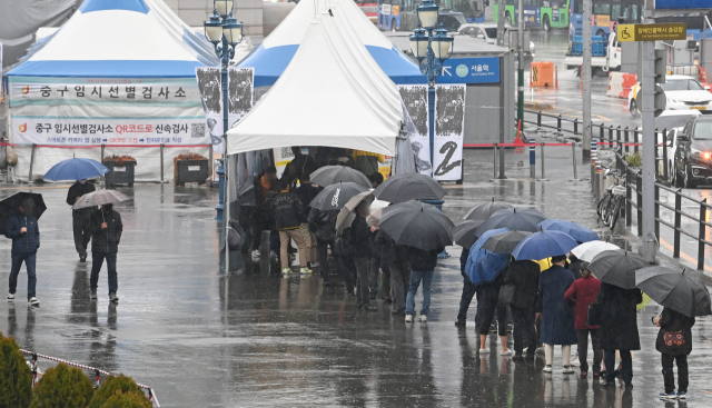 30일 서울역 광장 임시 선별 검사소를 찾은 시민들이 우산을 쓰고 검사를 기다리고 있다. /성형주 기자