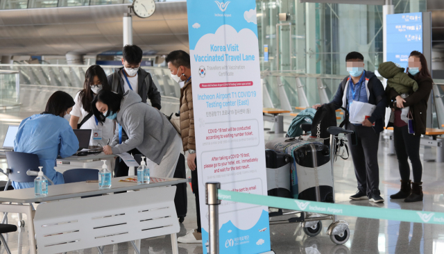 여객기 탑승객들이 1일 인천공항에서 코로나19 검사를 하고 있다./연합뉴스