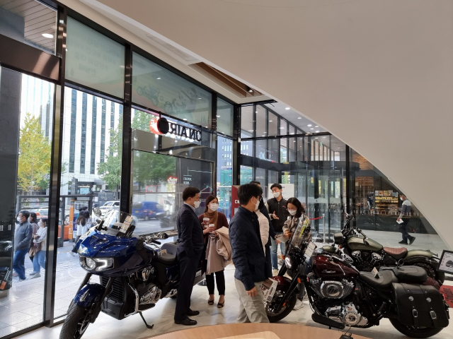 최근 서울 서소문에 있는 신한은행 ‘디지로그’ 지점에 전시된 ‘인디언모터사이클’의 제품을 방문객들이 살펴보고 있다. /사진 제공=신한은행
