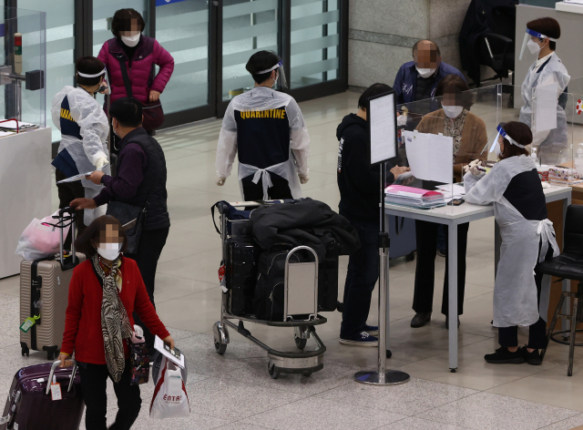 5일 오후 영종도 인천국제공항 입국장에서 방역 관계자들이 입국자들에게 안내를 하고 있다. /연합뉴스