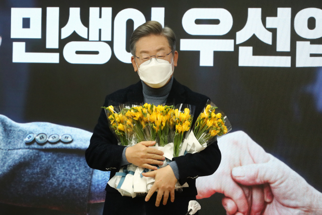 이재명 더불어민주당 대선 후보가 6일 서울 여의도 당사에서 열린 전국민선대위에 참석한 소상공인들이 준비한 꽃을 받아 들고 있다. /권욱 기자