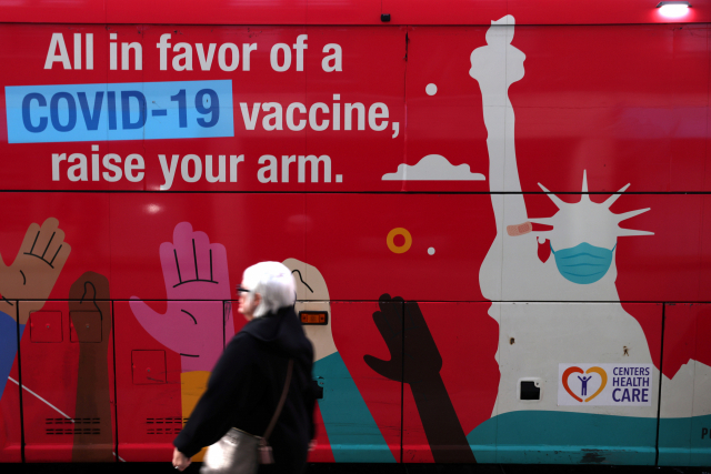 미국 뉴욕 맨해튼에서 7일(현지 시간) 한 시민이 백신 접종 독려 문구가 쓰여진 이동식 접종소 앞을 지나고 있다. /로이터연합뉴스