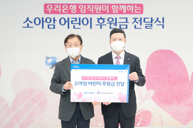 권광석(오른쪽) 우리은행장이 9일 서울 중구 우리은행 본점에서 소아암 어린이 지원을 위한 기부금을 전달한 뒤 기념촬영을 하고 있다. 사진 제공=우리은행