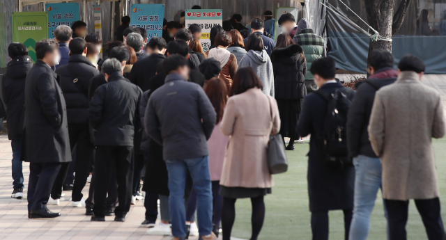 9일 서울시청 앞에 마련된 서울광장 신종 코로나바이러스 감염증(코로나19) 선별진료소에서 검사를 받으려는 시민들이 줄을 서고 있다.