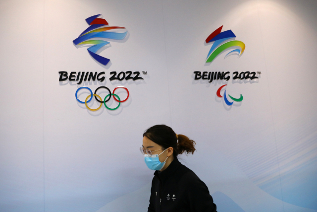 중국 베이징의 한 동계올림픽 시설에서 한 스태프가 2022 베이징 동계올림픽 로고 앞을 지나가고 있다. /로이터연합뉴스