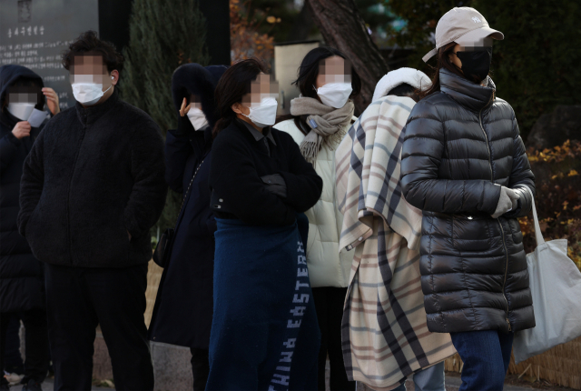 12일 오후 서울 송파구보건소 선별진료소에서 한 학생이 담요를 두른 채 코로나19 검사를 받기 위해 줄을 서고 있다./연합뉴스