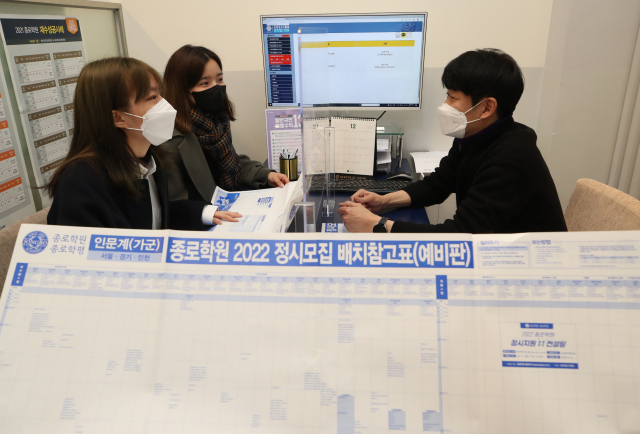 2022학년도 대학수학능력시험 성적표가 통지된 10일 서울 마포구의 한 학원에서 수험생들이 선생님과 배치표를 살펴보며 상담하고 있다. /연합뉴스