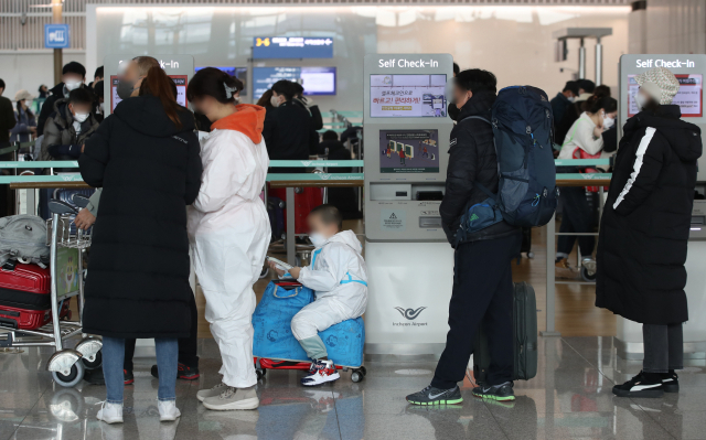 14일 영종도 인천국제공항 제1여객터미널 출국장에서 한 어린이가 방역복과 페이스실드를 착용한 모습./ 연합뉴스