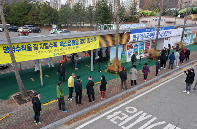 14일 오전 전남 함평엑스포공원 주차장에 마련된 임시 선별검사소에서 신종 코로나바이러스 감염증(코로나19) 검사를 받으려는 주민들이 줄 서 있다. 오미크론 변이 확진자가 지난 12일 첫 확인된 이후 함평읍은 주민들을 대상으로 전수조사 중이다./연합뉴스