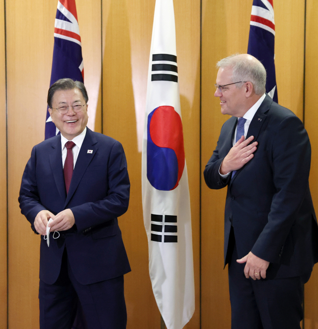 호주를 국빈 방문 중인 문재인 대통령과 스콧 모리슨 호주 총리가 13일 캔버라 국회의사당 내 대위원회실에서 열린 확대회담에 앞서 기념촬영을 위해 마스크를 벗고 있다./연합뉴스