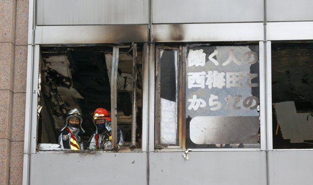 지난 17일 오전 일본 오사카시 번화가 빌딩에서 소방대원들이 화재현장을 살피고 있다./연합뉴스