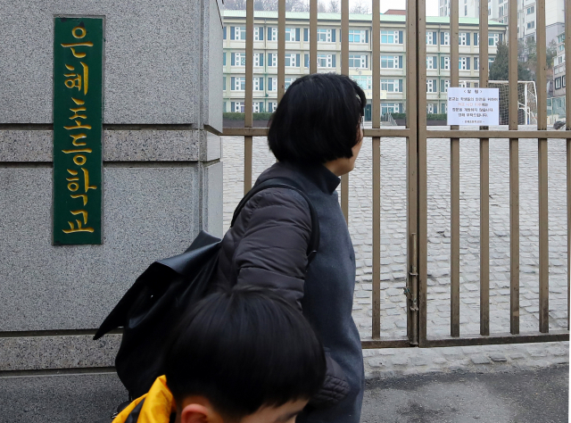 한 시민이 지난 2018년 1월 서울 은평구에 있는 은혜초등학교 정문 앞을 지나가고 있다. /연합뉴스