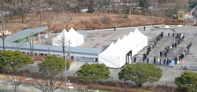 20일 오후 서울 잠실종합운동장 주차장에 마련된 코로나19 임시선별검사소를 찾은 시민들이 검사 순서를 기다리고 있다. /연합뉴스