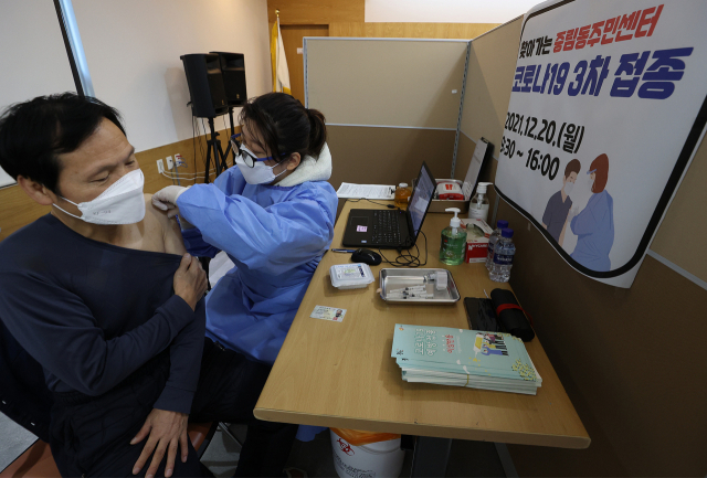 20일 서울 중구 중림동주민센터에서 한 시민이 코로나19 백신 3차 접종을 받고 있다./연합뉴스